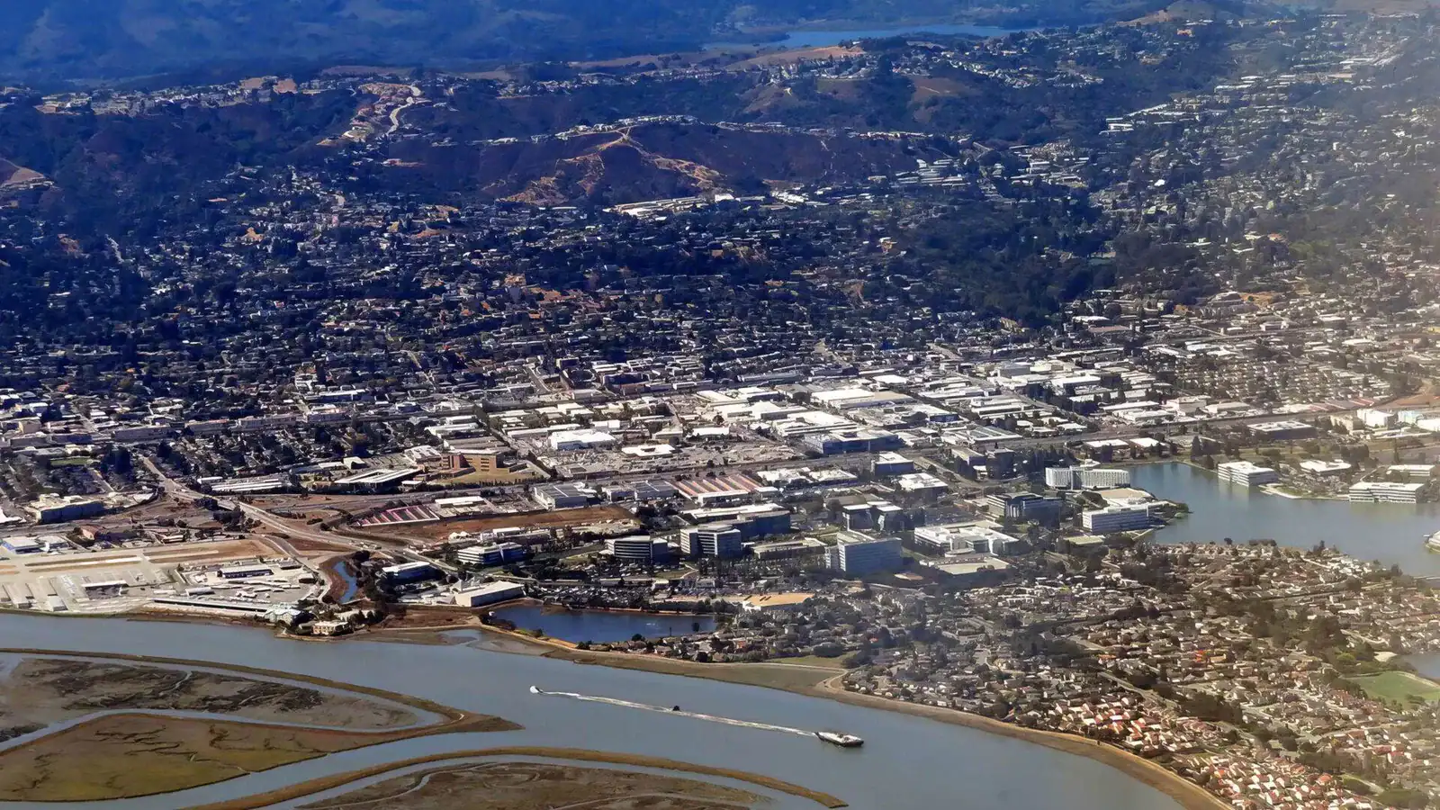 Aerial daytime view of a South Bay city with hillside homes and a marina inlet