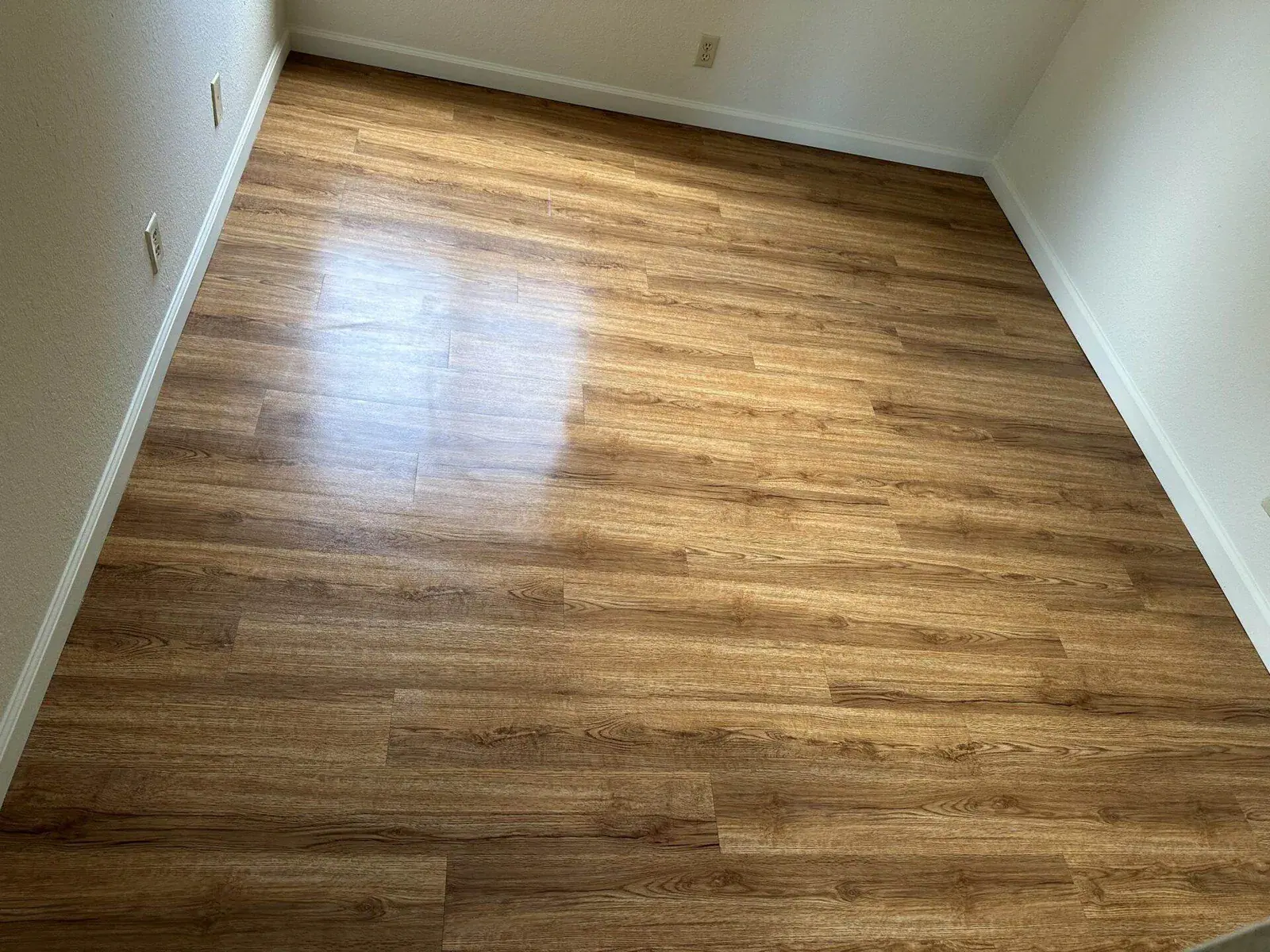 Empty room corner with clean glossy laminate flooring