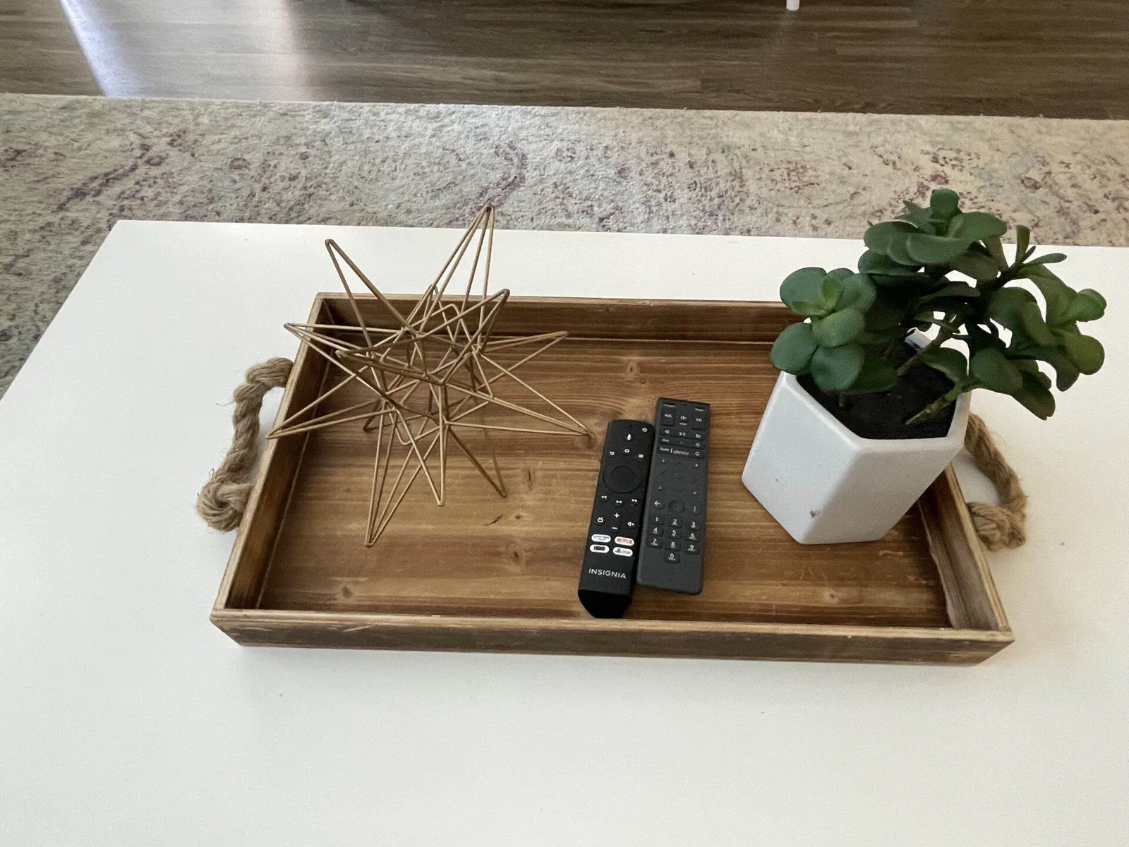 Organized wood coffee tray with remotes, decor star, and small plant