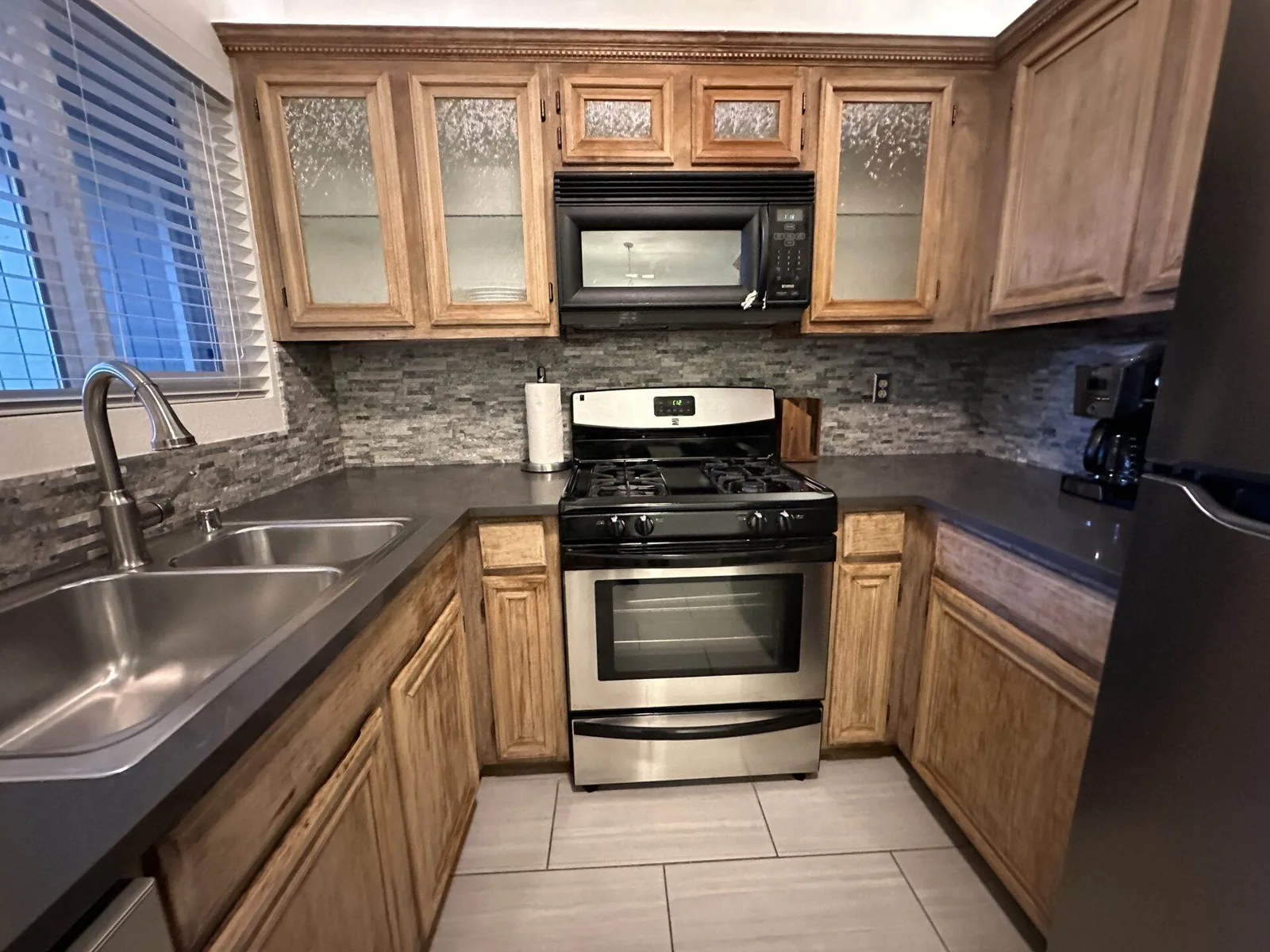 Clean kitchen with wood cabinets, gas range, and clear countertops