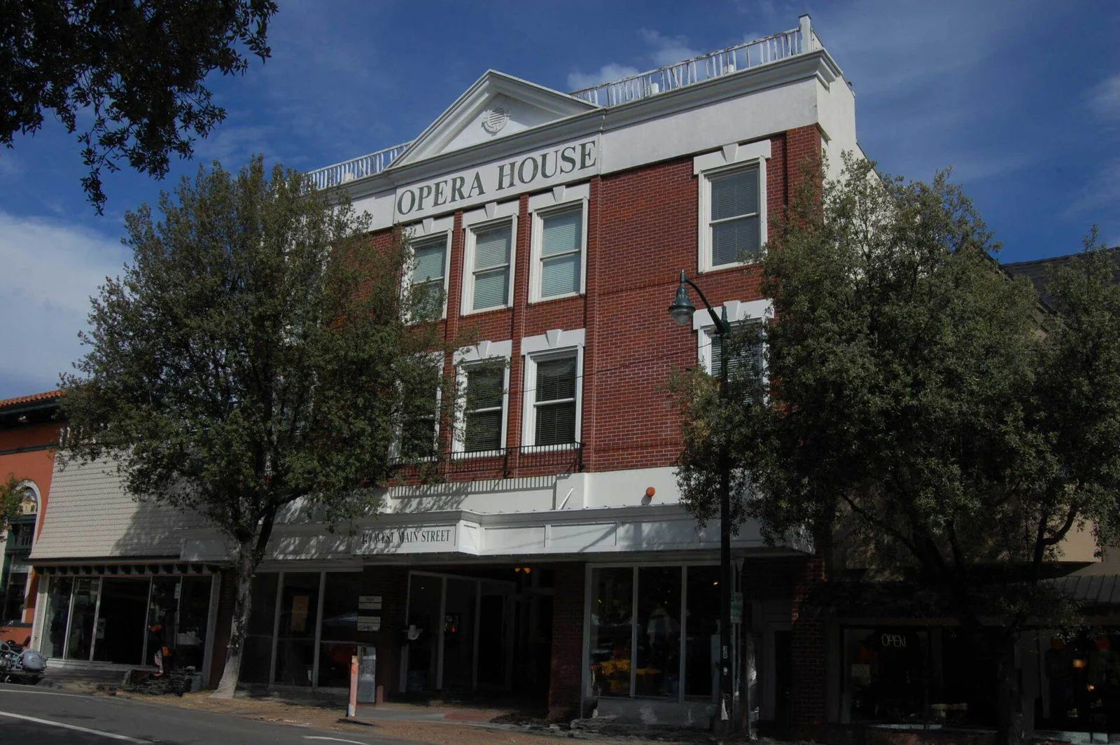 Historic red-brick Opera House building with white trim on Main Street in downtown Los Gatos, California.