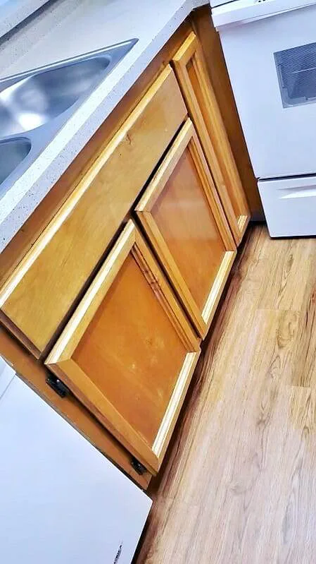 Empty wood kitchen cabinet drawers cleaned during a move-out service.