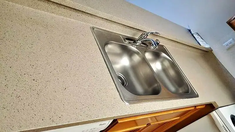 Clean stainless steel double sink and countertop during move-in/move-out cleaning.