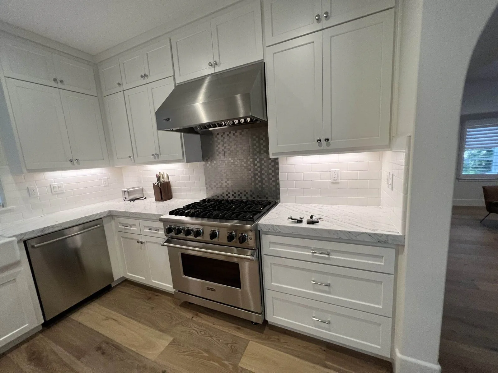 White kitchen with stainless range hood and gas range clean and staged after a deep clean.