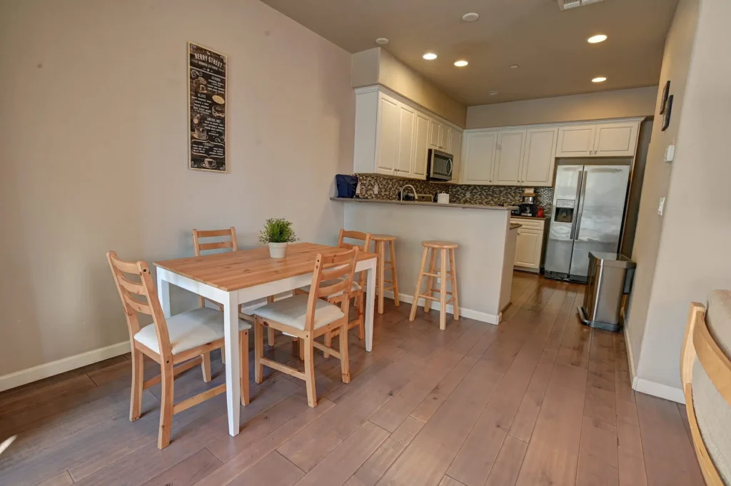 A small kitchen with a dining table and chairs that requires move-in or move-out cleaning.