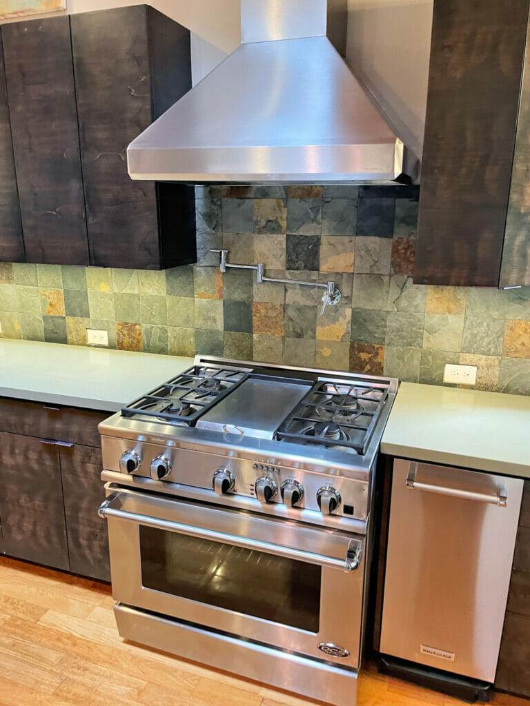 A stainless steel stove in a kitchen with master clean.