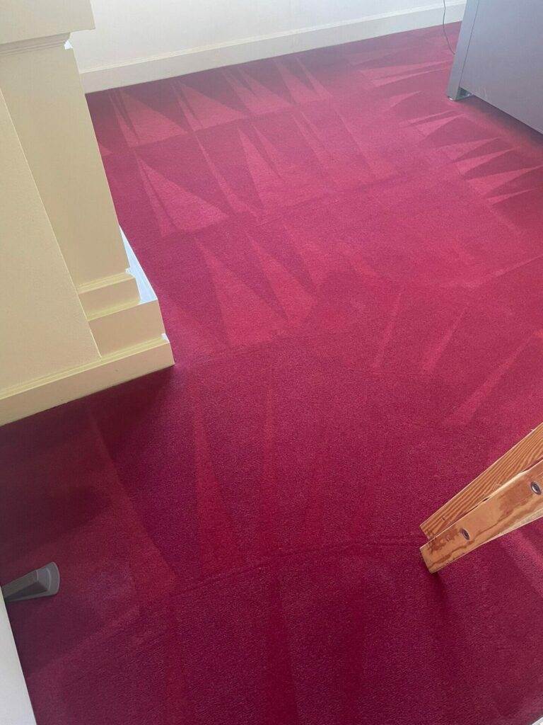 A commercial carpet is being cleaned in an office.