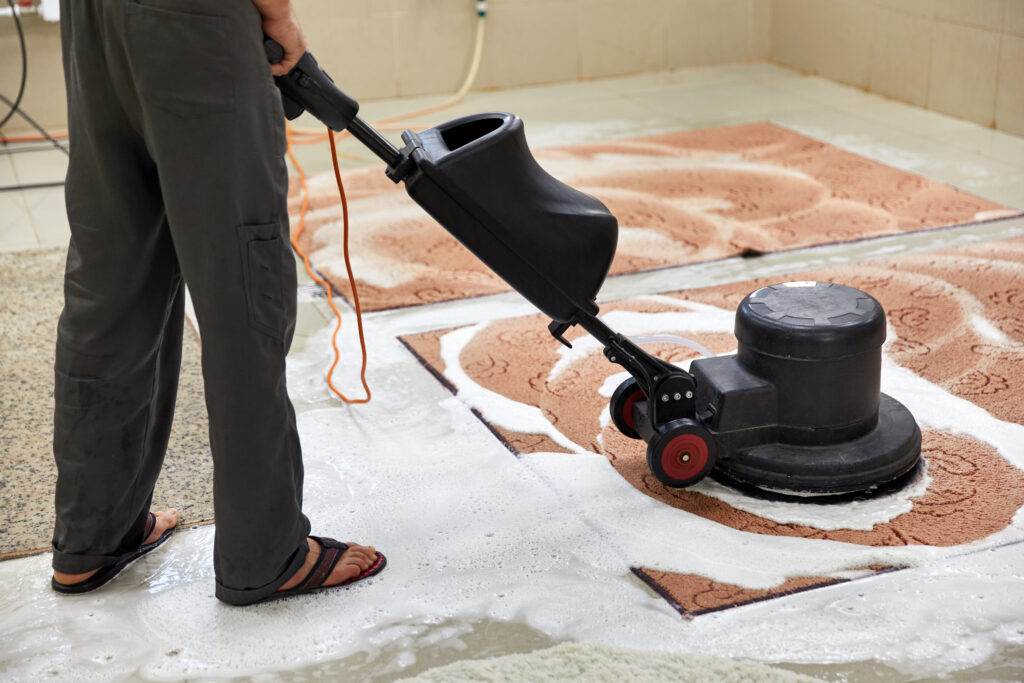 An expert cleaning service in San Jose is cleaning a tile floor in a living space.