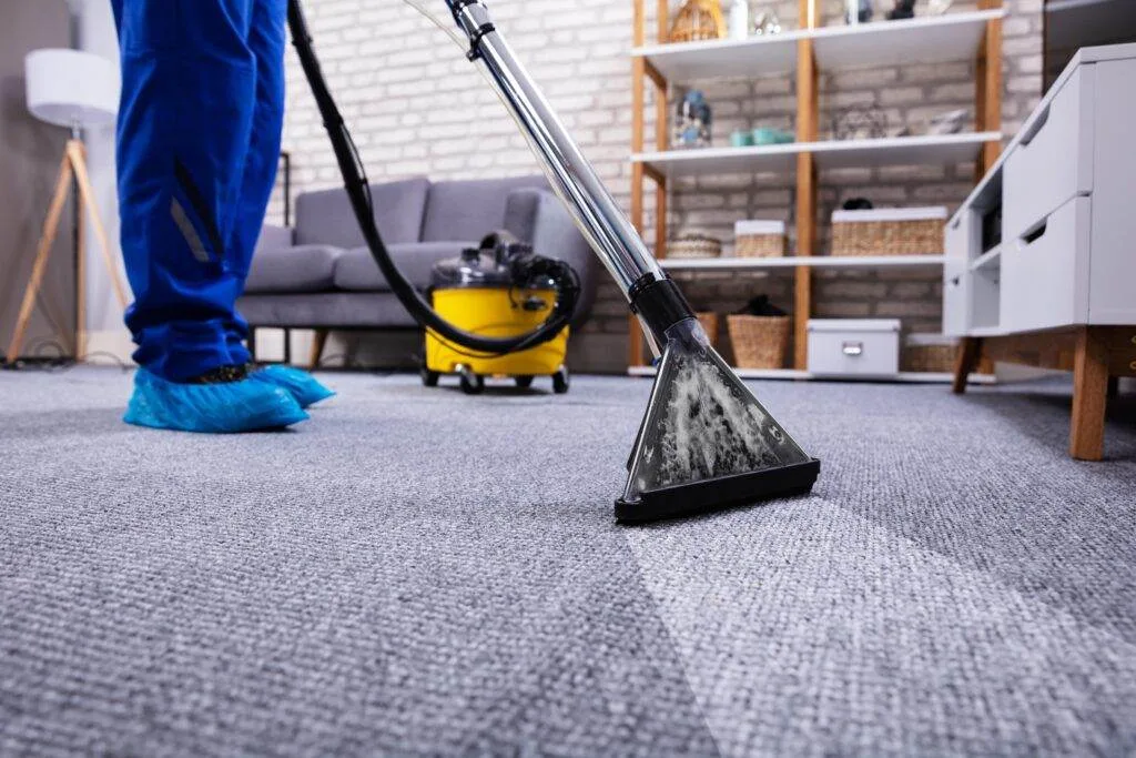 A man cleaning a carpet in a San Jose living room.