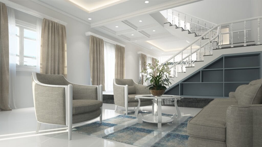 Modern living room in Campbell featuring gray armchairs, a sofa, round coffee table with a plant, large windows with beige curtains, and a staircase with built-in shelves—kept pristine with expert janitorial cleaning.