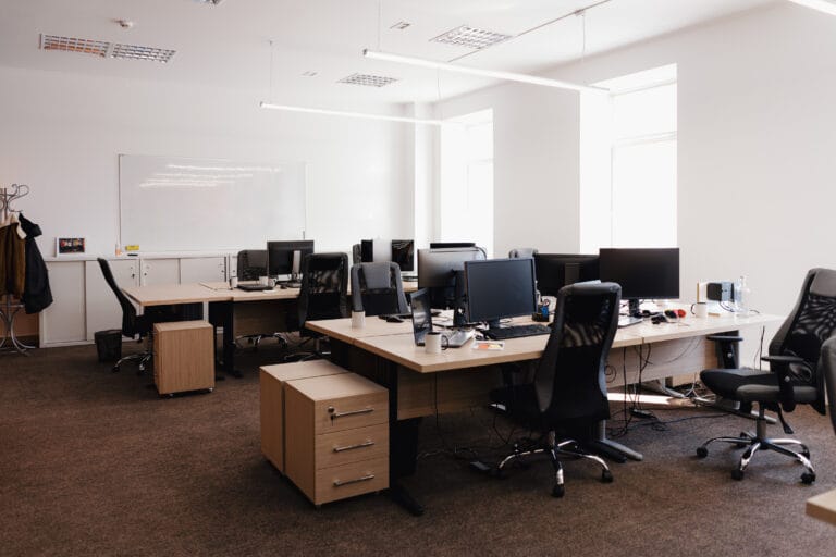Modern office in Los Gatos with multiple desks, computers, and chairs arranged in an open layout. The space is well-lit with large windows, a whiteboard on the wall, and maintained with professional janitorial cleaning for optimal office care.